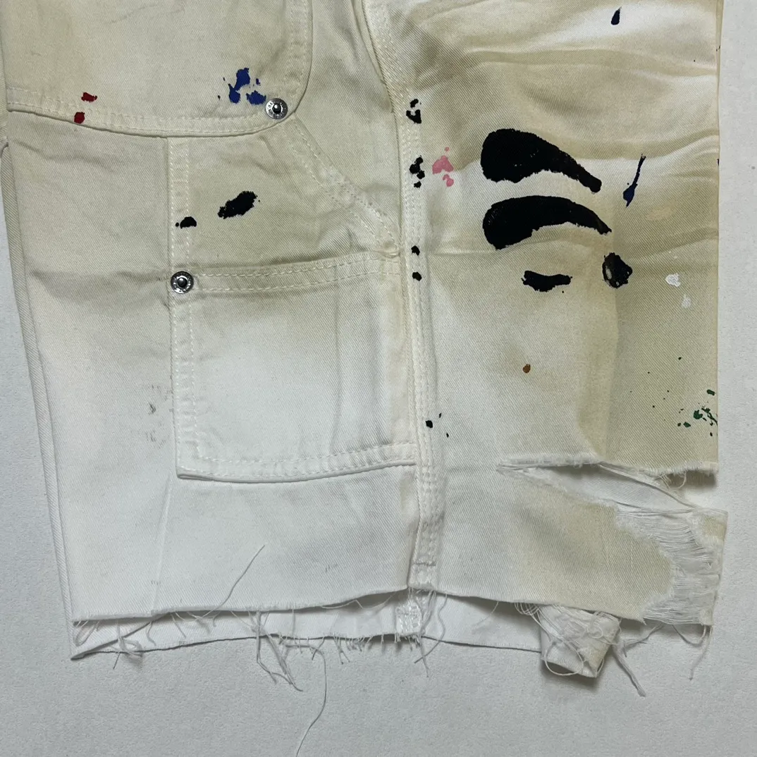 Close-up of details GALLERY DEPT. FLEA CARPENTER SHORTS Ink-splash knife-cut mud-dyed denim shorts Destroyed VINTAGE distressed denim shorts Distressed white S-XL Rewashed cement-dyed to make it distressed Knife cut holes and cat whiskers worn away Customized complete set of accessories with logo Handmade acrylic splash-ink graffiti